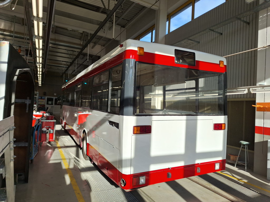 Auch das Heck kann sich schon wieder sehen lassen, weitere Bauteile sind bereits in Vorbereitung zur Endmontage. Die rote Stelle links auf dem Bus ist übrigens kein Bildfehler, der neue Lack spiegelt noch so stark, dass sich der Werkzeugkasten auf die Seitenwand mogeln konnte. (Foto: jz)